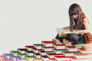A child sits on a stack of books