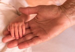 A parent holds a child's hand